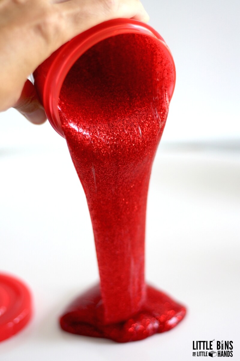 pouring red glitter glue slime out of container