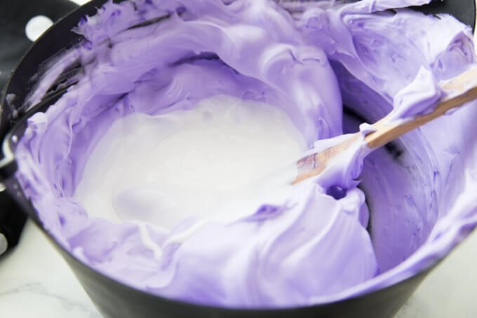 Adding glue to purple shaving cream in cauldron