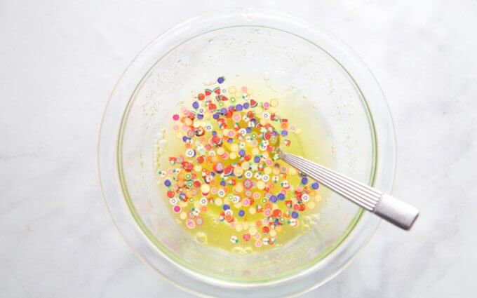Mixing fruit scented slime recipe with fun fruit confetti and jello powder