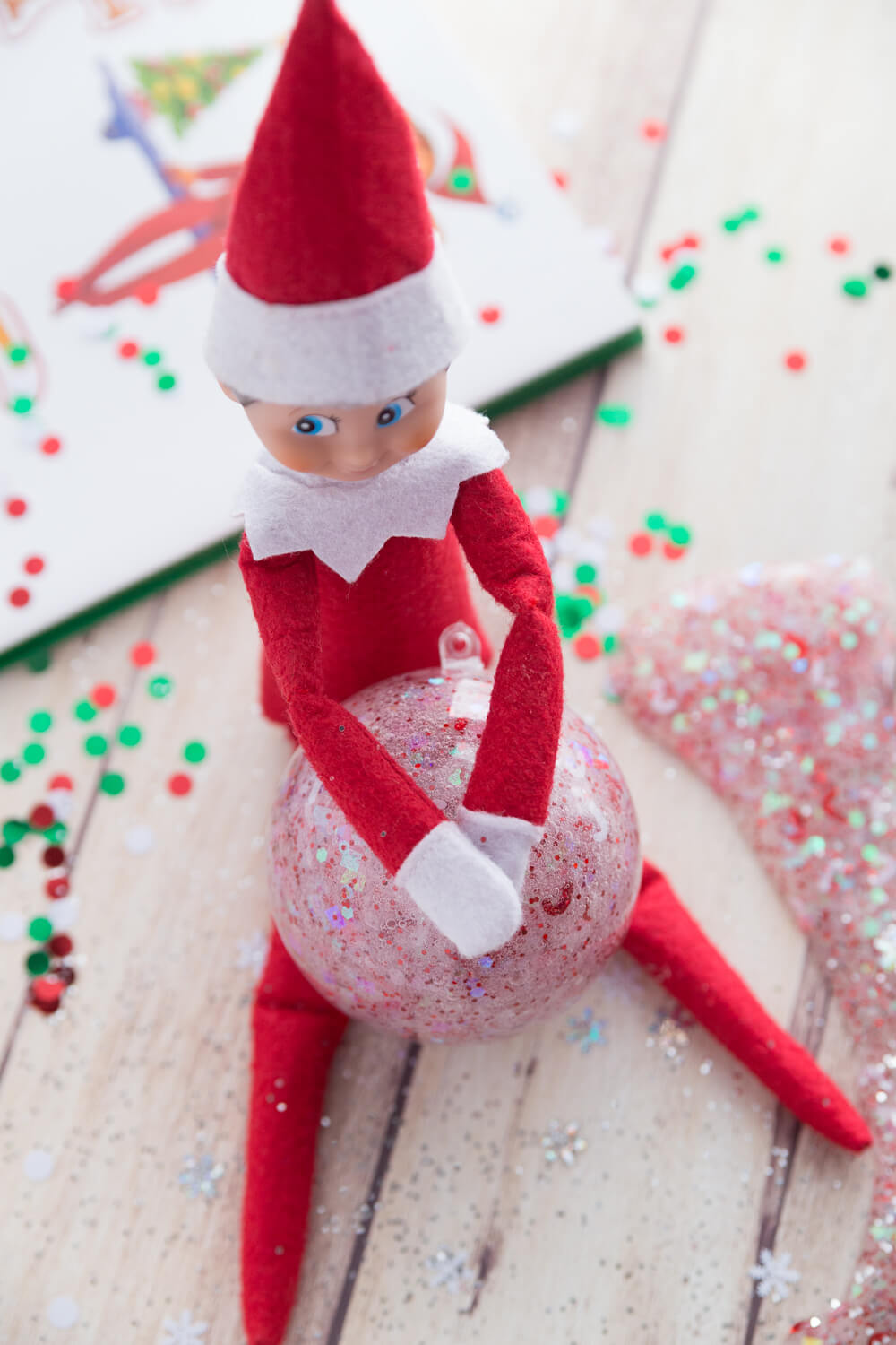 Elf on the Shelf holding slime ornament filled with homemade slime