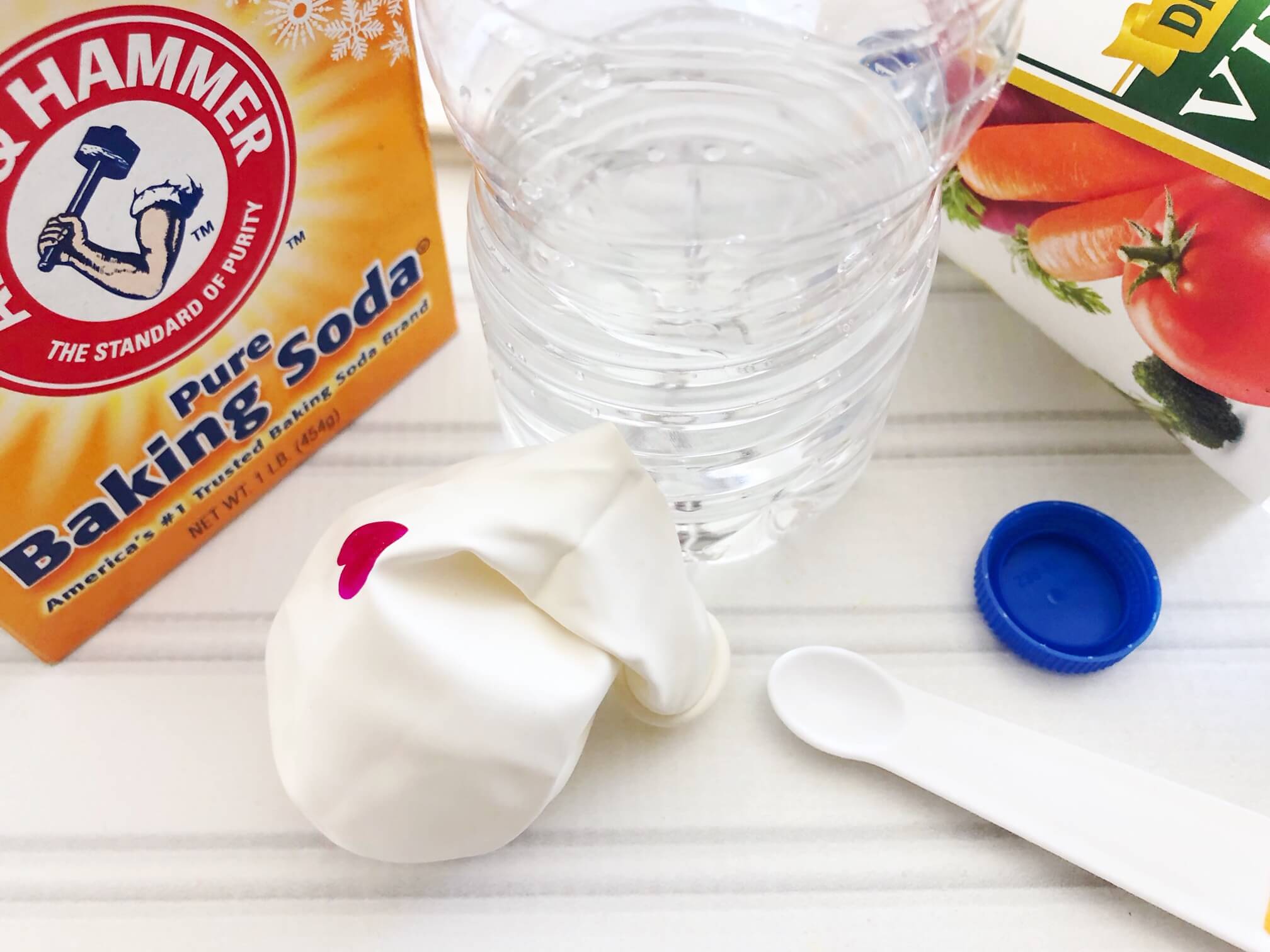 Adding vinegar to plastic bottle for baking soda balloon science experiment
