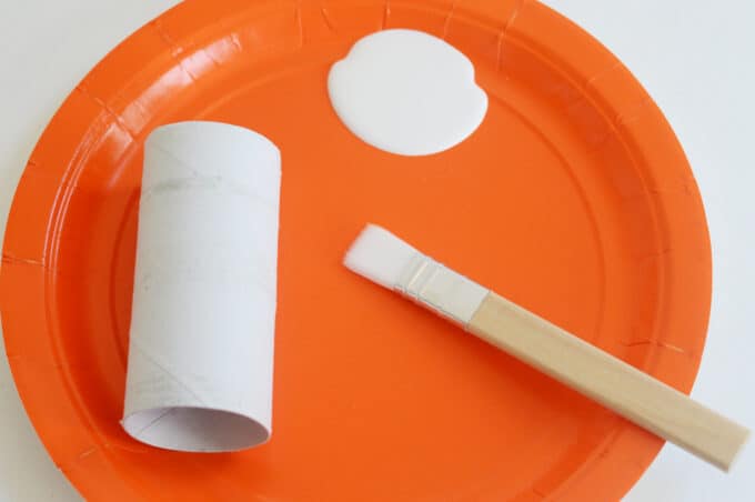 painting toilet paper tube with white paint