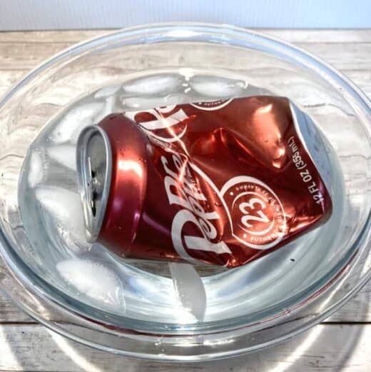Crushed Dr. Pepper can in a bowl of ice water