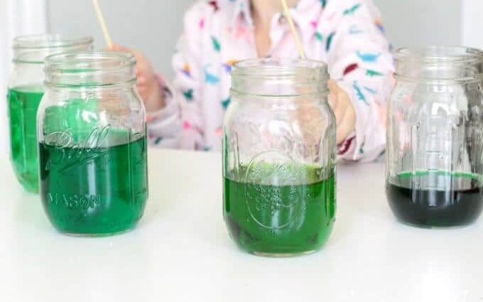 Mason jars filled partially with green water to make a water xylophone