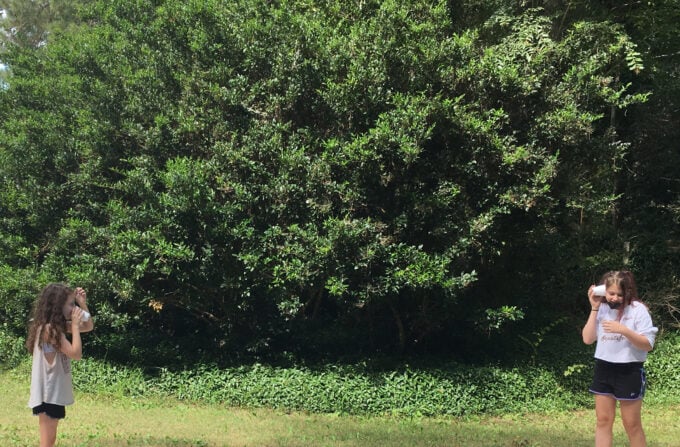 2 kids testing the cup and string telephone