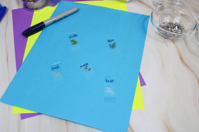 collection of microscope slides with salt, sand, pollen, glitter